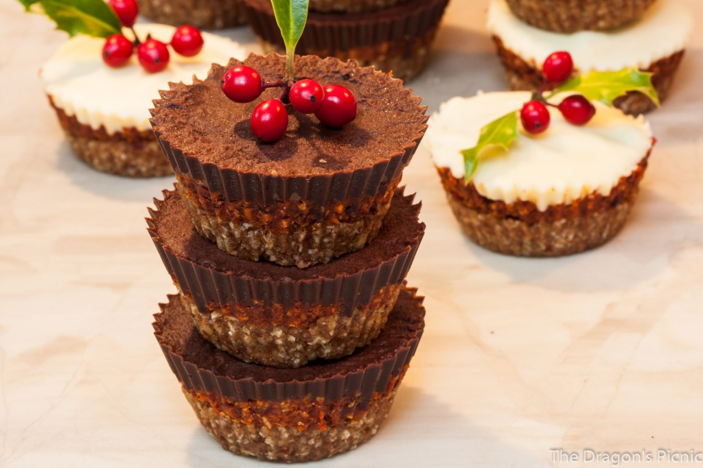 stack of gingerbread and cranberry dark chocolate cups with white chocolate cups in background with holly decorations