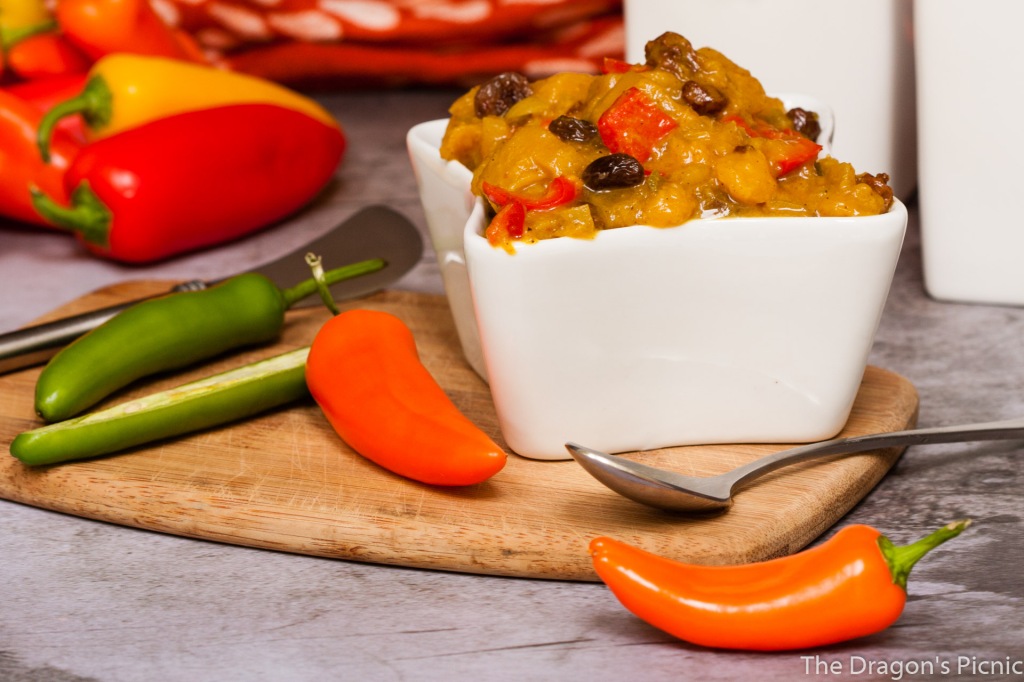 white dish of chutney surrounded by various coloured peppers